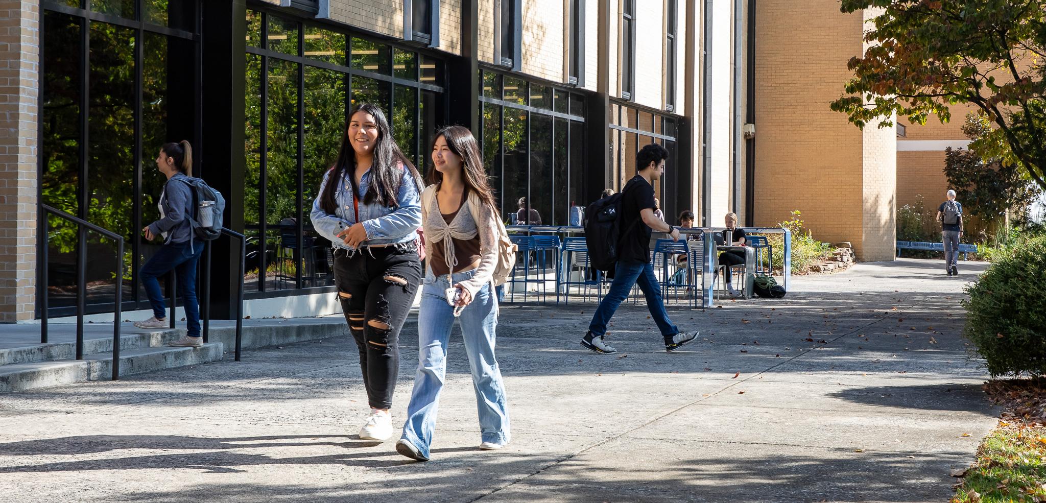 A walkway of campus with several students walking in various directions